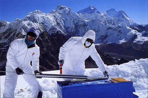 
Researchers extract a section of ice core at 5800m on the Nangai Gosum Glacier with Everest, Lhotse and Nuptse behind  - Trekking And Climbing in Nepal book
